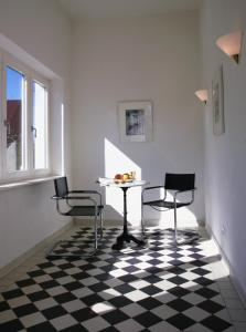 ein Esszimmer mit einem Tisch und Stühlen auf einem karierten Boden in der Unterkunft Villa Daheim - FeWo 01 in Ostseebad Kölpinsee