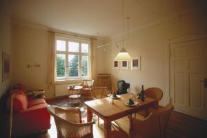 ein Wohnzimmer mit einem Tisch und Stühlen in der Unterkunft Villa Daheim - FeWo 01 in Ostseebad Kölpinsee