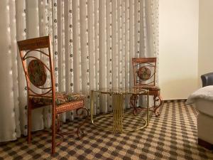 two chairs and a table in front of a curtain at Abu Mazen Hotel in Khirbat an Naşārá