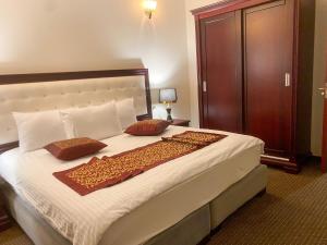 ein Schlafzimmer mit einem großen Bett mit zwei Kissen darauf in der Unterkunft Abu Mazen Hotel in Khirbat an Naşārá