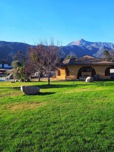 une maison dans un champ d'herbe verte avec un arbre dans l'établissement Tahiken, à Olmué