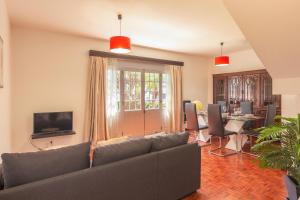 a living room with a couch and a dining room at Pilar House in Funchal