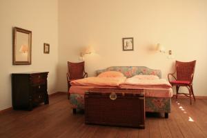a bedroom with a bed and a dresser and chairs at Villa Daheim - FeWo 02 in Kolpinsee