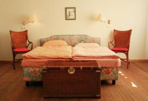 een slaapkamer met een bed en 2 stoelen bij Villa Daheim - FeWo 02 in Kolpinsee