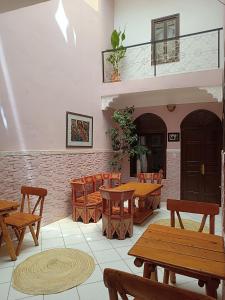 um restaurante com mesas e cadeiras de madeira em Dar Suncial em Marrakech