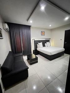 a hotel room with a bed and a couch at Rigg Hotel in Apapa Eleko