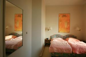 a bedroom with two beds and a mirror at Villa Daheim - FeWo 04 in Kolpinsee