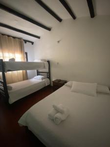 1 dormitorio con 2 literas y toallas. en Casa Naturhola, en Villa de Leyva