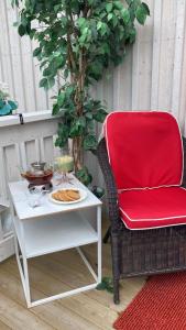 a red chair sitting next to a table with a plate of food at Charmig apartens in à house in stockholm in Stockholm