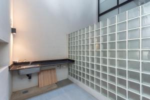 a bathroom with a sink and glass tiled walls at Live Soho Boutique & Apartments Palermo Hollywood in Buenos Aires