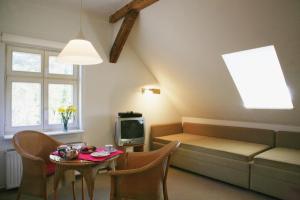 ein Wohnzimmer mit einem Sofa, einem Tisch und einem TV in der Unterkunft Villa Daheim - FeWo 06 in Ostseebad Kölpinsee