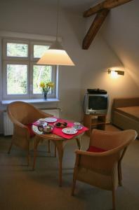 un soggiorno con tavolo, sedie e TV di Villa Daheim - FeWo 06 a Kolpinsee