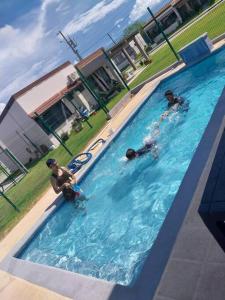 Tres personas nadando en una piscina en Tropical Oasis, Verano Inolvidable!, 
