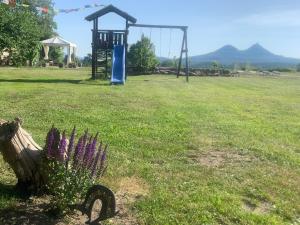 a park with a playground and a swing at Bezva relax Bezděz in Luka