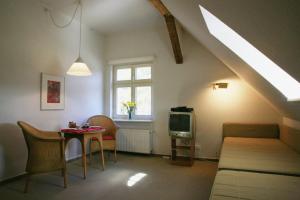 un soggiorno con letto, tavolo e TV di Villa Daheim - FeWo 06 a Kolpinsee