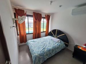 的住宿－Tropical Oasis, Verano Inolvidable!，一间卧室设有一张床和两个窗户。