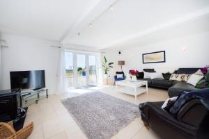 a living room with a couch and a tv at Sea View Luxury Beach House in Crosby