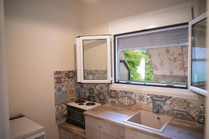 a kitchen with a sink and two windows at DIMITRA APARTMENTS in Pefki