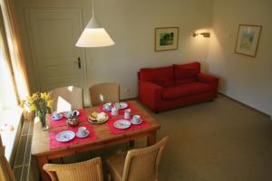 a living room with a table and a red couch at Villa Daheim - FeWo 07 in Kolpinsee