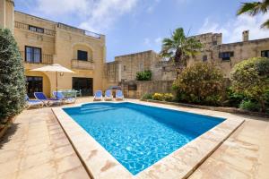 a swimming pool in the courtyard of a building at Gozo Escape in Għasri