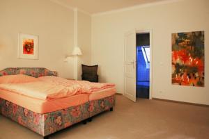 ein Schlafzimmer mit einem Bett und einem Sofa darin in der Unterkunft Villa Daheim - FeWo 07 in Ostseebad Kölpinsee