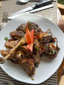 a white plate of food on a table at CAPELLA RESORT (ELEMENTAITA, KENYA) in Nakuru