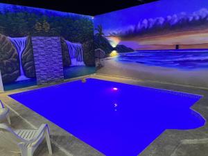 uma piscina num quarto com iluminação azul em RG Sol 1 em Pantoja
