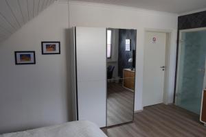 1 dormitorio con una puerta corredera de cristal que conduce a una habitación en Privatzimmer mit eigenem Bad und Küche, en Burgwedel