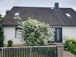 una casa blanca con una puerta negra y una valla en Privatzimmer mit eigenem Bad und Küche, en Burgwedel