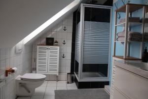 a bathroom with a toilet and a glass shower at Privatzimmer mit eigenem Bad und Küche in Burgwedel