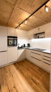 巴特特爾茨的住宿－Bad Tölz Mittendrin，厨房铺有木地板,配有白色橱柜。