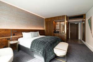 a bedroom with a bed and a chair in a room at Horizon by SkyCity in Auckland