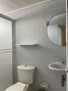 uma casa de banho branca com um WC e um lavatório em HospedajeLR em Barrancabermeja