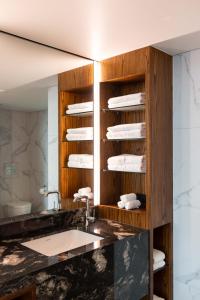 a bathroom with a sink and a counter with towels at Horizon by SkyCity in Auckland