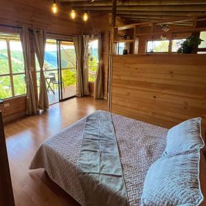 ein Schlafzimmer mit einem Bett in einem Zimmer mit Fenstern in der Unterkunft Monte Santa Elena in Medellín