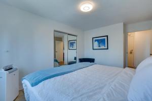 a bedroom with a large white bed and a mirror at Downtown Seattle Condo with Rooftop Deck and Views! in Seattle