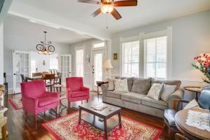 a living room with a couch and red chairs at Lake Charles Vacation Rental - Walk to the Lake! in Lake Charles