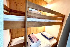 2 literas en una cabaña de madera con un libro en Spacious bright apartment en Combloux