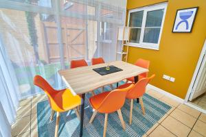 uma sala de jantar com uma mesa de madeira e cadeiras laranja em Spacious 4-bed, 3-bath home perfect for large groups em Tamworth