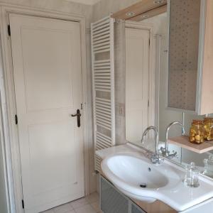La salle de bains blanche est pourvue d'un lavabo et d'un miroir. dans l'établissement Casa Tanja, à Pescara