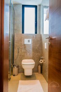 a bathroom with a toilet and a glass shower at SOLEA - Super central, comfortable and modern apartment in Accra