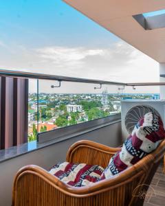 a balcony with two chairs and a fan at SOLEA - Super central, comfortable and modern apartment in Accra