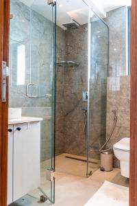 a shower with a glass door in a bathroom at SOLEA - Super central, comfortable and modern apartment in Accra