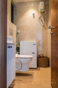 a bathroom with a toilet and a camera on the wall at SOLEA - Super central, comfortable and modern apartment in Accra