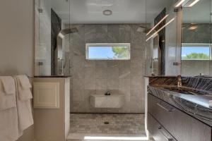 a bathroom with a shower and a sink and a mirror at @ Marbella Lane - Eccentric 4BR Modern Ranch Home in Reno +40 photos