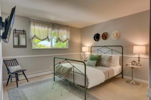 a bedroom with a bed and a chair and a window at @ Marbella Lane - Eccentric 4BR Modern Ranch Home in Reno