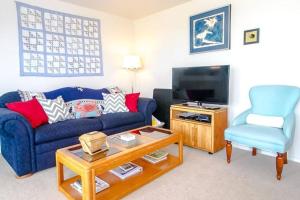 sala de estar con sofá azul y silla en Seawatch - Come watch the sea, en Long Beach