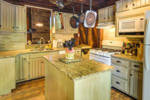 a kitchen with wooden cabinets and a counter top at Family-Friendly DuBois Cabin with Community Pool! in DuBois