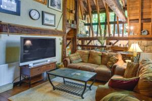 uma sala de estar com sofás e uma grande televisão em Family-Friendly DuBois Cabin with Community Pool! em DuBois