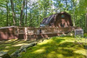 uma cabana de madeira na floresta com um deque e uma casa em Family-Friendly DuBois Cabin with Community Pool! em DuBois